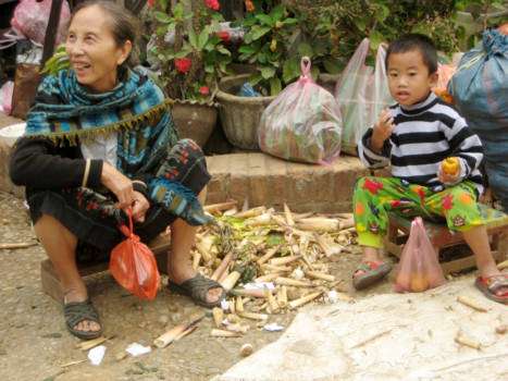 Laos - Moeder en zoontje bij een mini markt in Luang Prabang