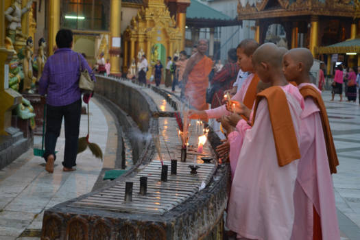 Yangon - Boedistische meisjes steken een kaarsje op