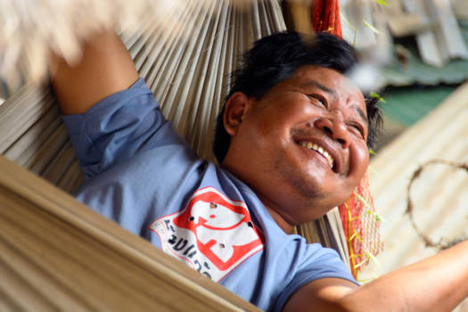 Cambodja - Father of a poor family in his hammock. Extremely happy with what he does have.