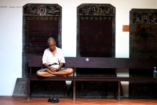 Pulau Penang - Monk praying in bouddhist church.