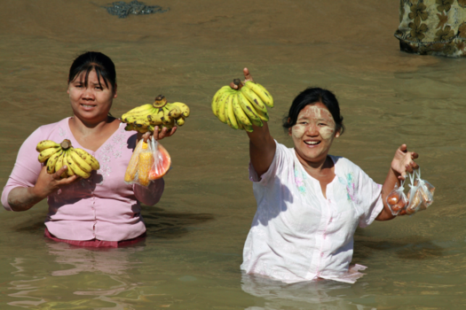 Myanmar - Fruitverkoopsters in een haventje aan de Irrawaddy rivier benaderen hun clientèle.