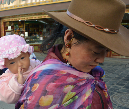 Lhasa - Vrouw met kind op de rug in de buurt van Jokhang tempel in Lhasa