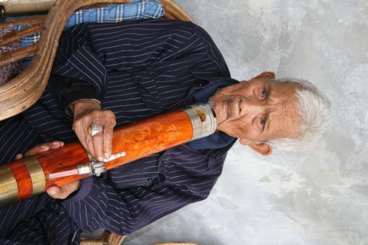 Cambodja - 96 jaar oude Chinese man uit Ban Rak Thai, genietend van zijn pafje