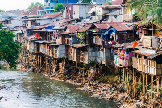 Japan - Zelfgebouwde huisjes langs de rivier in Jakarta.