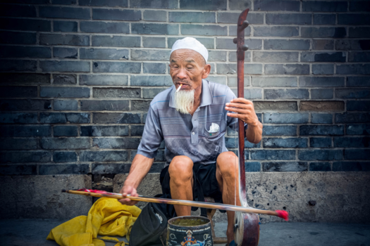 China - An old chinese man playing his instrument