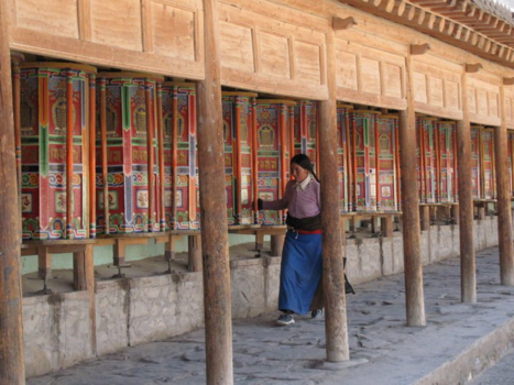 China - Pelgrims draaien de gebedsmolens in Xiahe, China