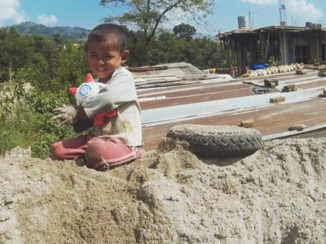 Nepal - Dit gebied was zwaar getroffen door de aardbeving in 2015 en dit kindje zat toe te kijken hoe zijn moeder een nieuw huis aan het bouwen was.